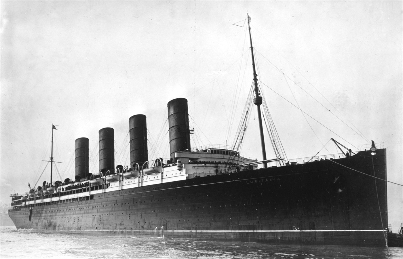 RMS Lusitania arriving in port, photographed between 1907 and 1913. The four-funnelled Cunard liner is shown low in the water with steam rising from her funnels.